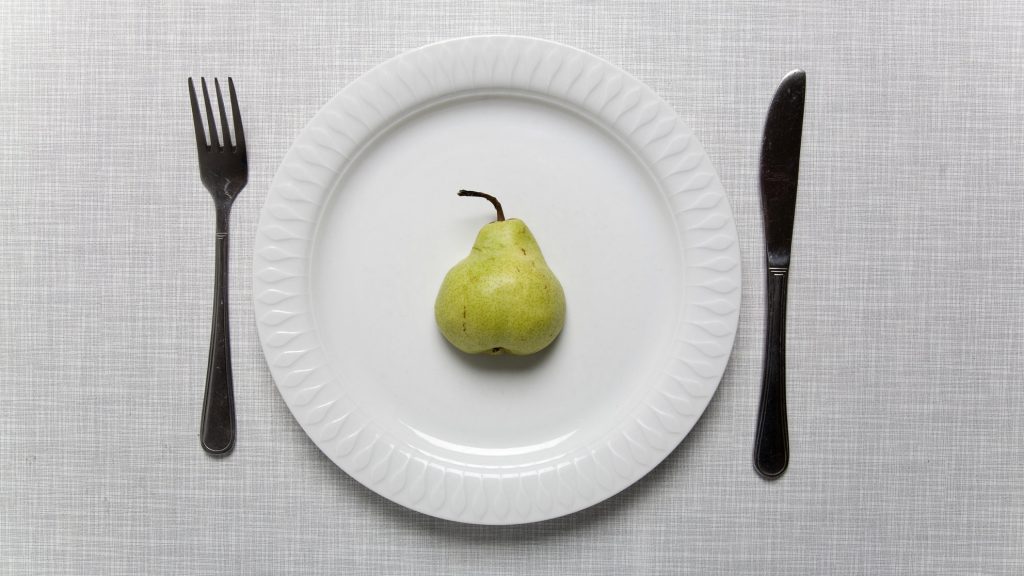 Pear on a plate with fork and knife